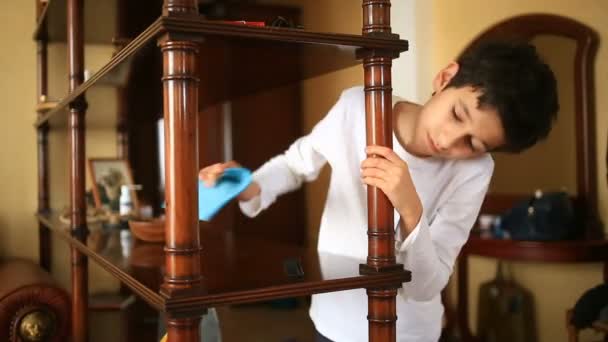 The boy-teenager unwillingly wipes the dust off the shelf. Cleaning of the childrens room. Confusion in the room for teens — Stock Video