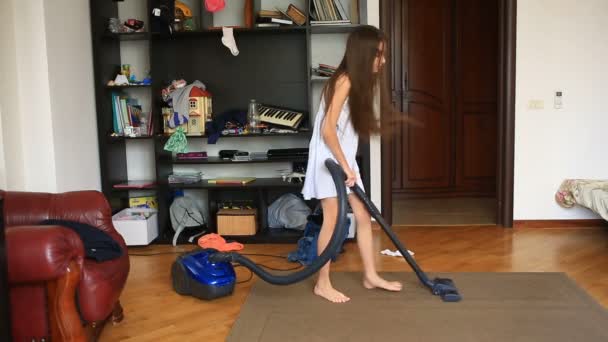 La ragazza pulisce il tappeto nella stanza con un aspirapolvere — Video Stock