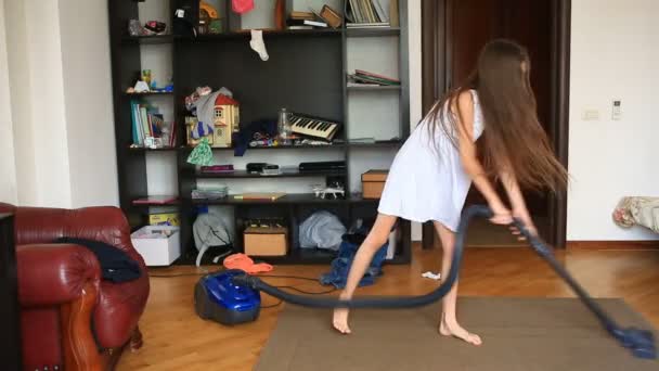La ragazza pulisce il tappeto nella stanza con un aspirapolvere — Video Stock