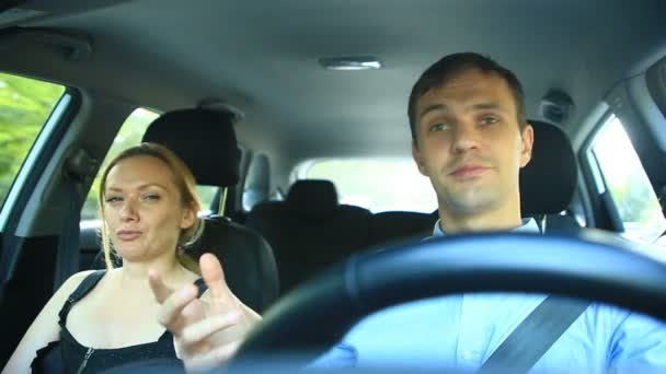 Pareja montando en el coche, un hombre y una mujer viajan juntos en el coche a través de las calles de la ciudad y alegremente hablar, reír — Vídeo de stock