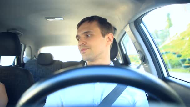 Bir adam bir araba kullanıyor, sokaklarda şehrin ve şen şakrak arabada bir adam gülüyor yolcu ile sohbet eden sürücüler. Direksiyondaki adam — Stok video