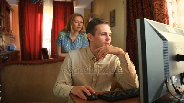 Trabalhando no computador em casa, seu marido está satisfeito com a transação bem sucedida, sua esposa está satisfeita com — Vídeo de Stock