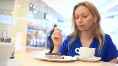 Bir kafede kahve çikolatalı kek ile içme kadın