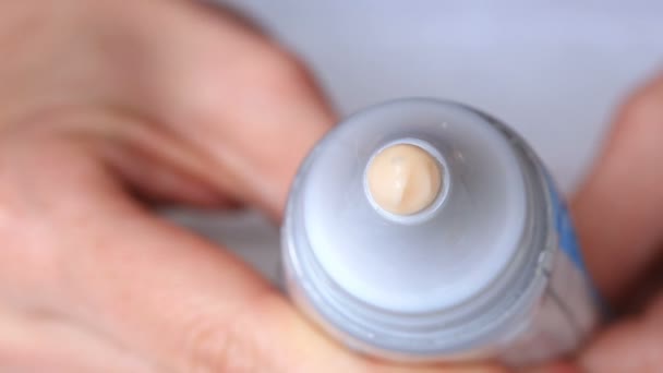 Creme branco hidratante espremido de um tubo sobre um fundo branco — Vídeo de Stock