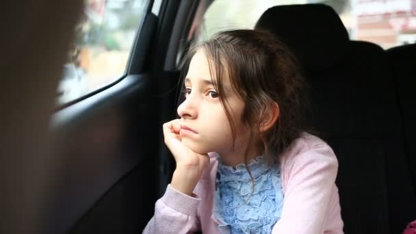 Petite fille, ennuyée dans la voiture - regardant par la fenêtre - reflet de rue — Video