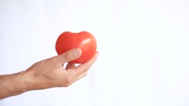 El tutar bir domates beyaz bir arka plan üzerinde mans