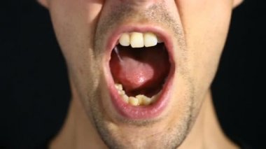 adam siyah bir zemin üzerine kameraya çığlık atıyor. Ağız ve gülümserim yakın çekim