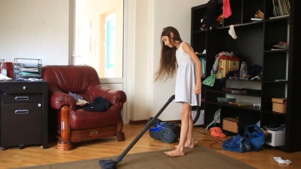 Flickan rengör mattan i rummet med en dammsugare — Stockvideo