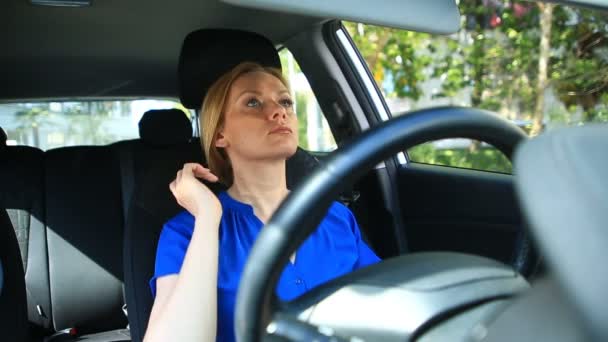 Perempuan menyesuaikan makeup dan gaya rambut saat duduk di roda mobil — Stok Video