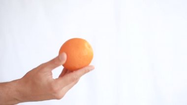 Elini tutan meyve beyaz bir arka plan üzerinde mans. Turuncu