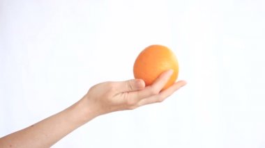 Beyaz bir arka plan üzerinde meyve tutan el. Turuncu