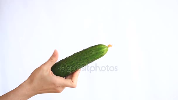 A mans hand holding a vegetable on a white background. cucumber — Stock Video