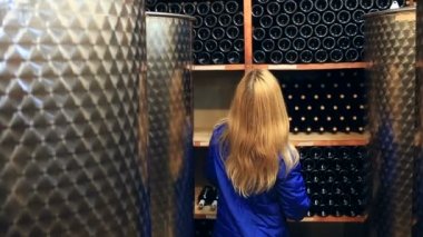 Bir kadın şarap şarap mahzeninde seçer..