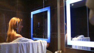 Bir kadın onun baş ve vücut duşta yıkar.