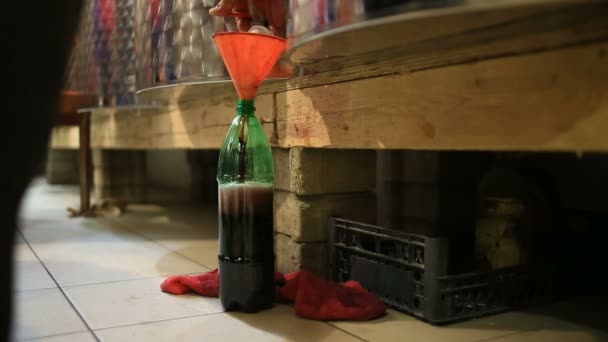 Чоловік вливає вино в пляшку з бочки. вино Сховище . — стокове відео