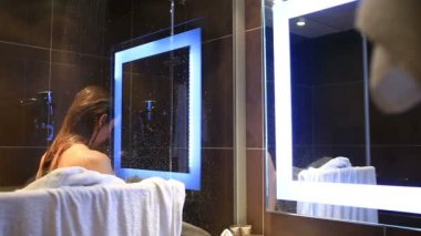 Bir kadın onun baş ve vücut duşta yıkar.