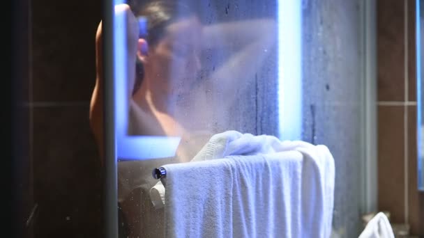 Μια γυναίκα που πλένει το κεφάλι και το σώμα στο ντους. — Αρχείο Βίντεο