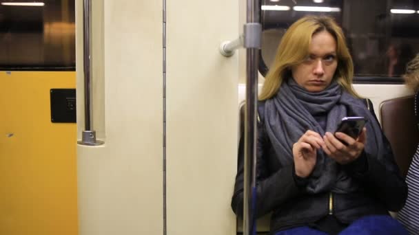 Fille attrayante dans le métro train en utilisant un smartphone. Jeune femme naviguer sur Internet avec la technologie à écran tactile . — Video