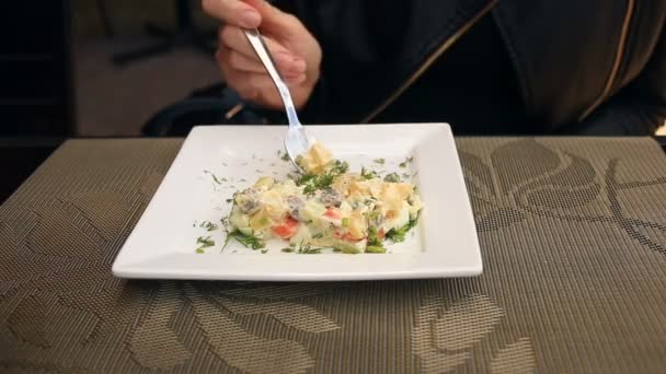 El hombre está comiendo una ensalada de papas con un plato cuadrado. primer plano — Vídeos de Stock