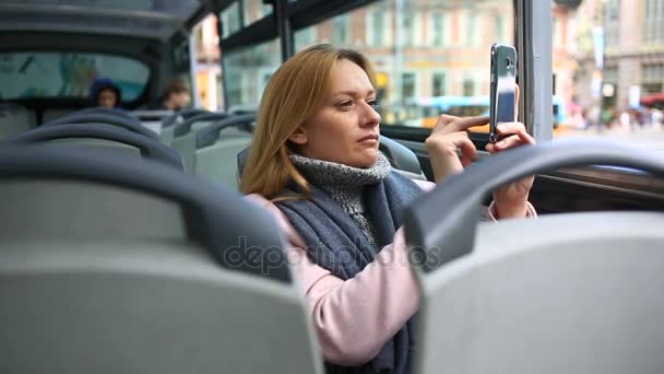 Akıllı telefon ile turistik gezi otobüsle seyahat genç güzel kadın — Stok video