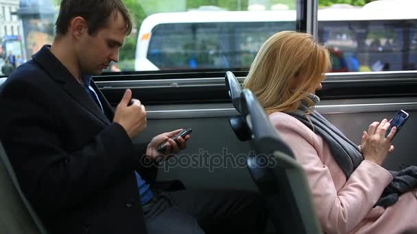 Uomo e donna che viaggiano in autobus turistico turistico, con uno smartphone — Video Stock