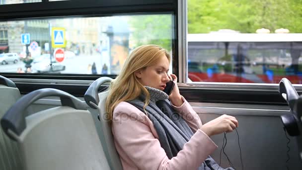 Jeune femme béatifique voyageant en bus touristique, avec téléphone intelligent — Video