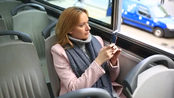 Junge schöne Frau, die im Touristenbus mit Smartphone unterwegs ist — Stockvideo