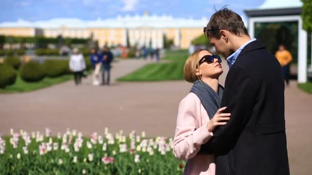 幸せなカップルの男と女を抱いて、天気のいい日に、春の公園でキス. — ストック動画