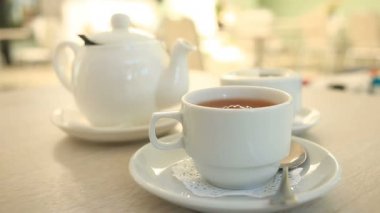 Birisi bir rafine şeker şeker kaseden Maşa ile alır ve bir shaku çay ile koyar