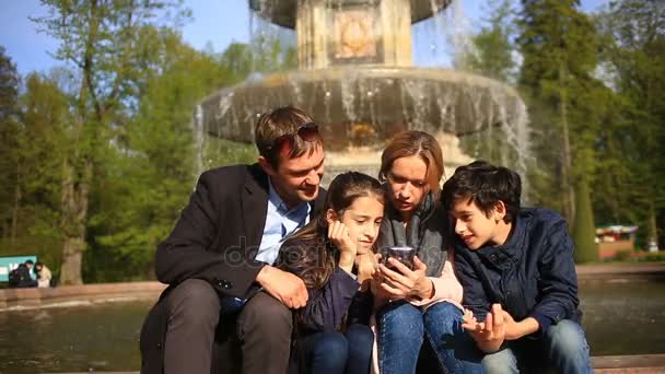 Familia feliz tomando selfie en el teléfono móvil en el parque en un día soleado — Vídeos de Stock