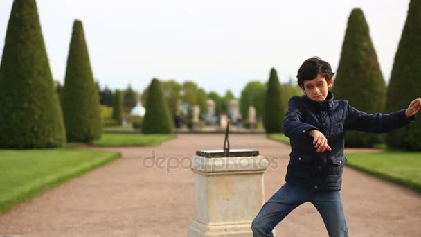 Grappige Kaukasische jongen dansen op groen gras gazon in een park op zonnige zomerdag — Stockvideo