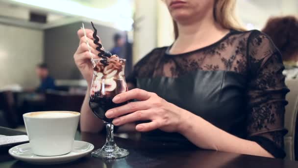 Жінка їсть десерт і п'є каву в кафе, крупним планом — стокове відео