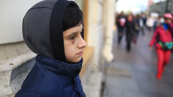 The boy is a teenager with a hematoma and a bruised eye that looks into the camera. — Stock Video