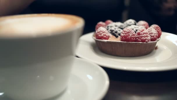 Donna che mangia dessert e beve caffè in un caffè, primo piano — Video Stock