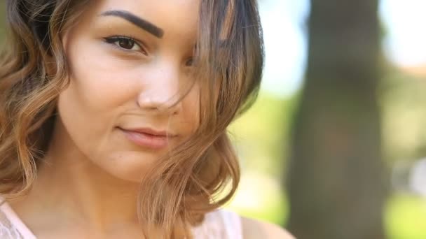 Vacker ung brunett flicka med bruna ögon söt leende och tittar på kameran — Stockvideo