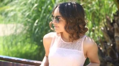 Kahverengi gözleri gülümseyerek ve kameraya bakarak şirin güzel genç esmer kızla