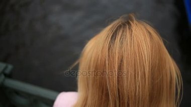 Bir kadın bir ceket bir köprüde duruyor ve siyah su tepeden bakıyor. O intihar etmek istiyor