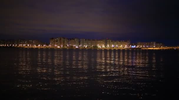 Ночное городское освещение, муниципальные здания мерцают на воде ночью — стоковое видео