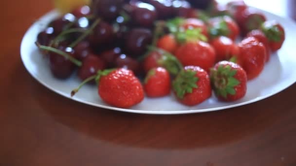 Schotel met kersen en aardbeien close-up — Stockvideo