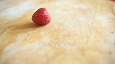 Kendi ekseni etrafında döner bir ahşap tahta üzerinde bir çilek berry yatıyor