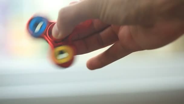 Mehrfarbiger, rot-gelb-blauer Handspinner oder zappelnder Spinner, der sich auf seiner Hand dreht. — Stockvideo