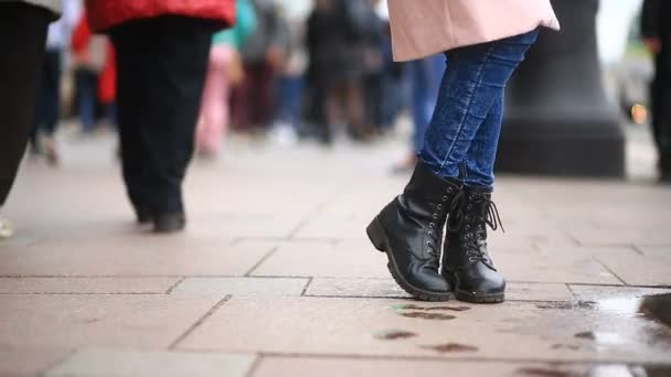 Los pies de un hombre que quiere ir al baño en medio de una calle llena de gente — Vídeo de stock