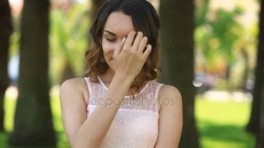 Kahverengi gözleri gülümseyerek ve kameraya bakarak şirin güzel genç esmer kızla