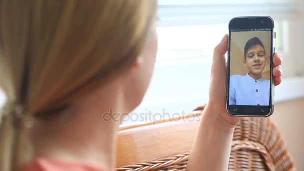 Una mujer está realizando videochat en un teléfono inteligente con un niño — Vídeo de stock