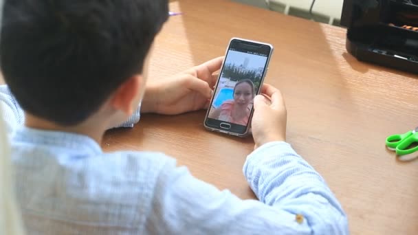 Niño adolescente sostiene un video chat con una mujer en un teléfono inteligente — Vídeo de stock