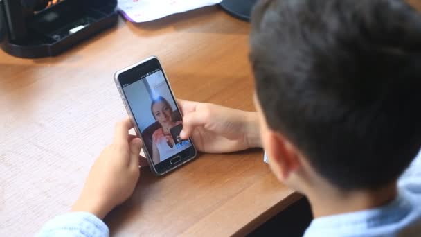 Boy teenager holds a video chat with a woman on a smartphone — Stock Video