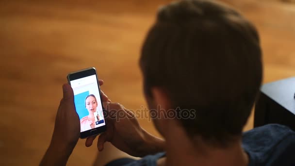 Ο άνθρωπος κατέχει μια συνομιλία μέσω βίντεο με μια γυναίκα σε ένα smartphone — Αρχείο Βίντεο