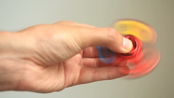 Mehrfarbiger, rot-gelb-blauer Handspinner oder zappelnder Spinner, der sich auf seiner Hand dreht. — Stockvideo
