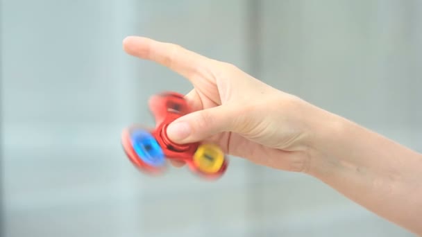 Mångfärgade, röd-gul-blå hand spinner eller fidgeting spinner, roterar på mans hand. — Stockvideo