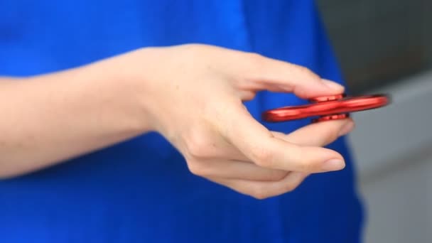 Vícebarevný, červená žlutá modrá ruka číselník nebo ošívat přadlena, rotace v mans ruku. Žena točí přadláka vrtět na ulici — Stock video